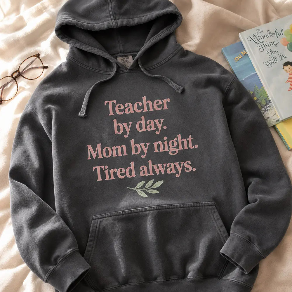Teacher by day hoodie folded on linen